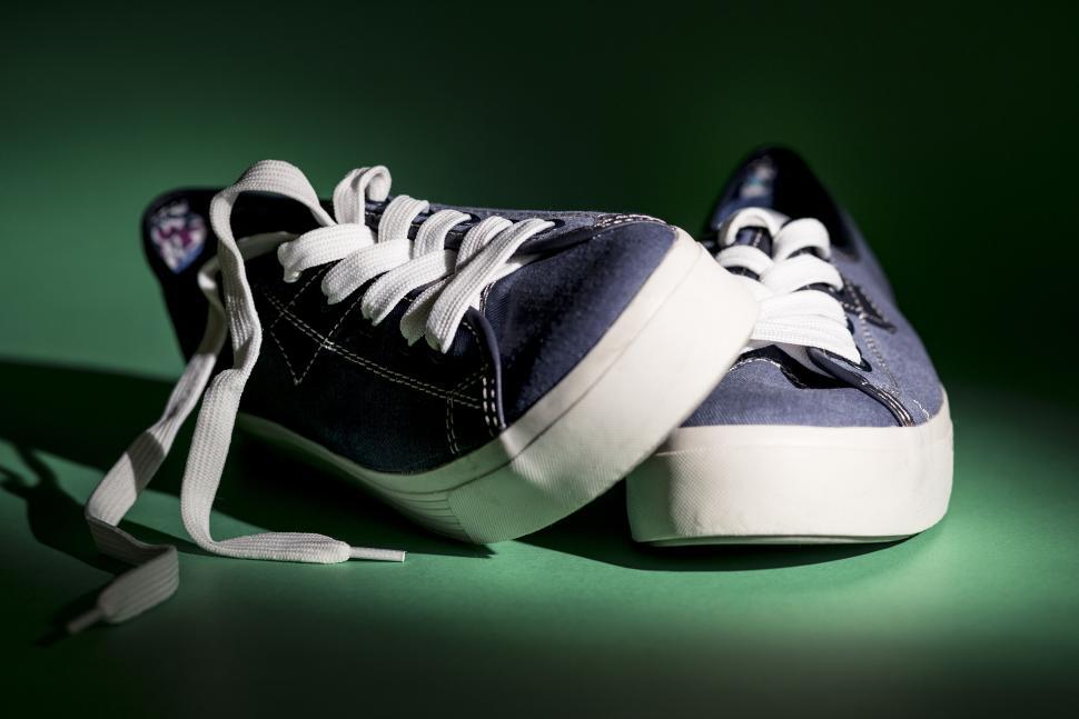 Free Image of Pair of casual sneakers with white laces on green surface. 