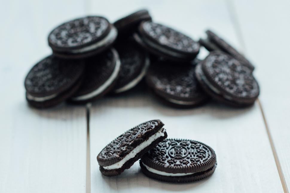 Free Image of Pile of chocolate cookies with cream filling on table 