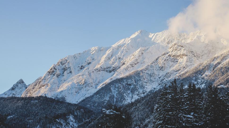 Free Image of Snow-covered mountain range under clear blue sky 
