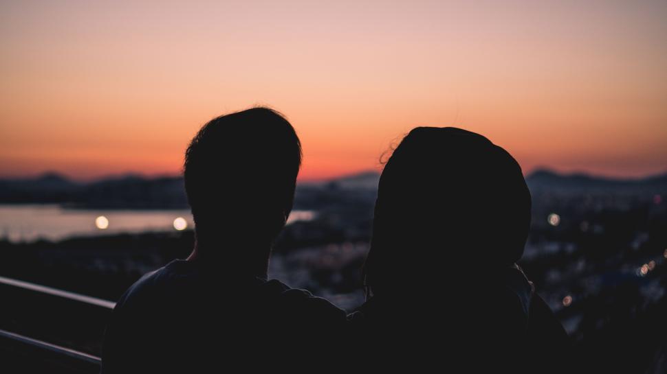 Free Image of Silhouette of two people enjoying a scenic sunset view. 