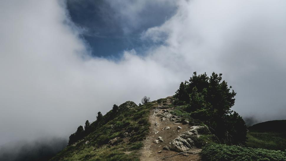 Free Image of Rocky mountain trail leading upward into the misty sky. 