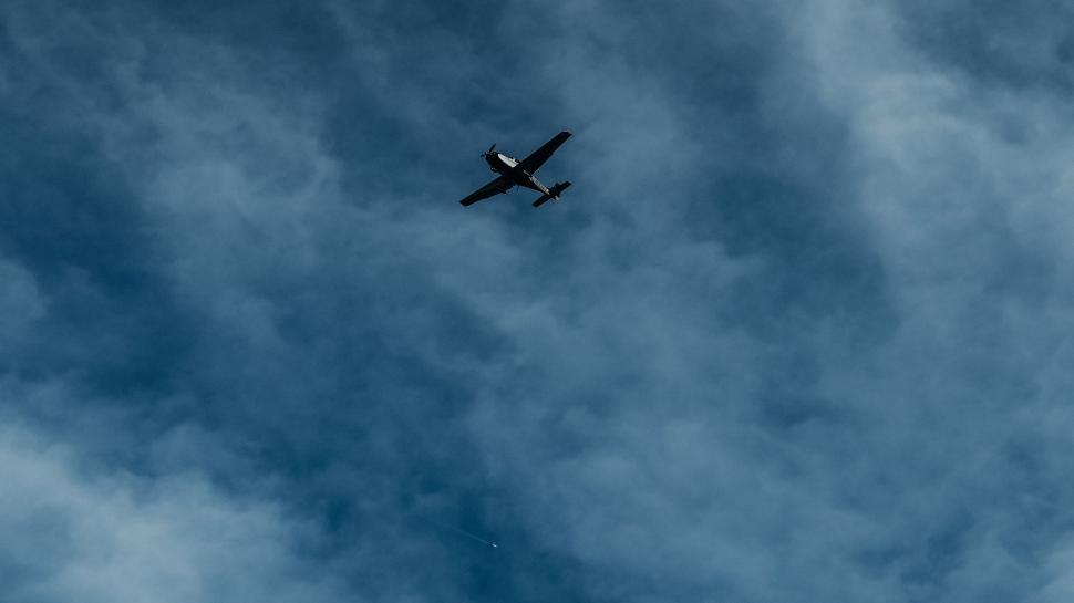 Free Image of Single propeller plane soaring above dense cloud cover 