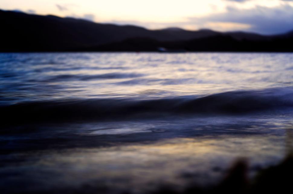Free Image of Calm lake water reflecting hills during serene twilight 