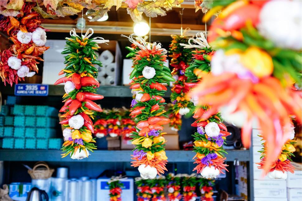 Free Image of Colorful chili peppers and garlic hanging at market stand 