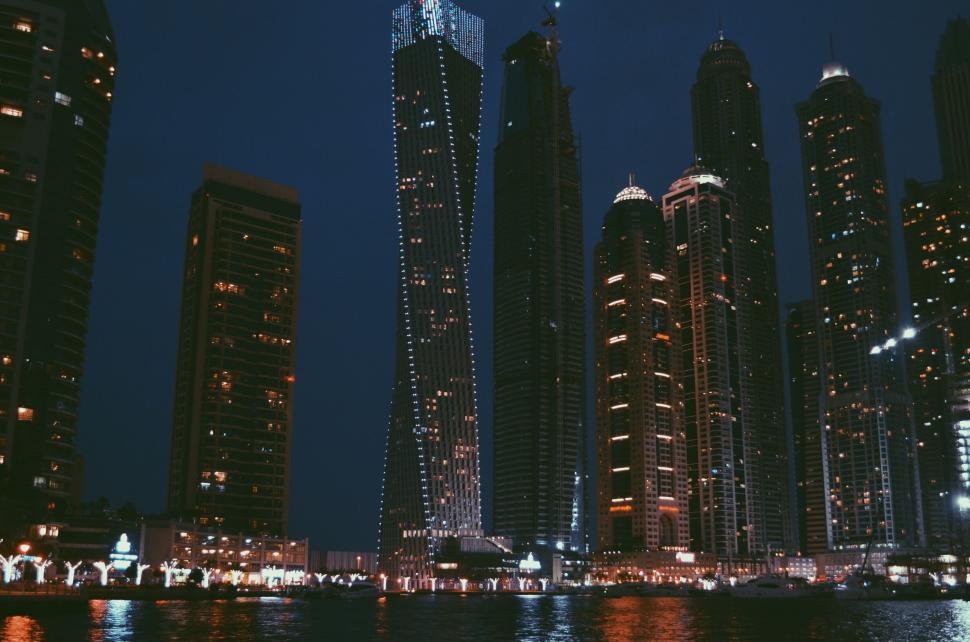Free Image of Night cityscape of illuminated modern skyscrapers by water 