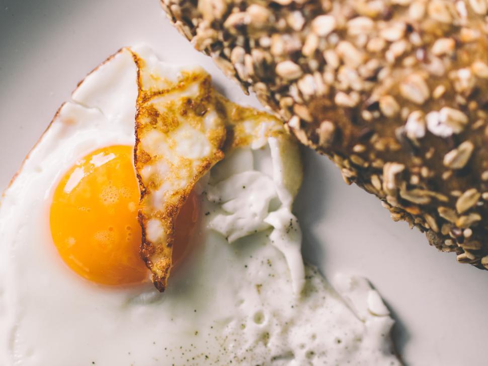 Free Image of Sunny side up egg with muesli bread close-up shot 