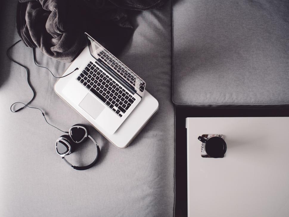 Free Image of Laptop and headphones on a gray sofa, work setup. 