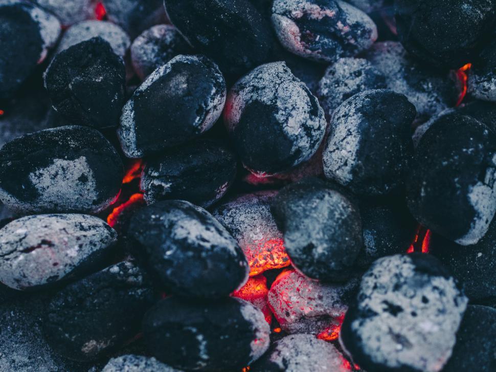 Free Image of Hot embers glowing underneath a collection of coals. 