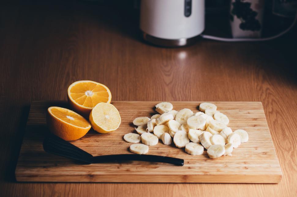 Free Image of Sliced bananas and citrus fruits on wooden board. 