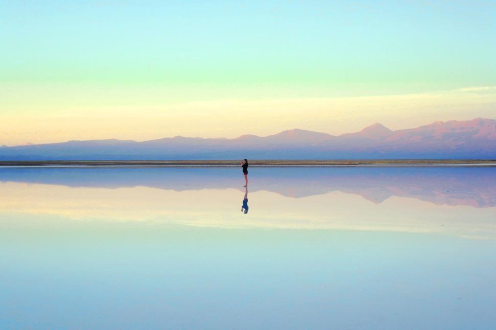 https://freerangestock.com/sample/180729/person-standing-on-reflective-surface-in-serene-landscape.jpg