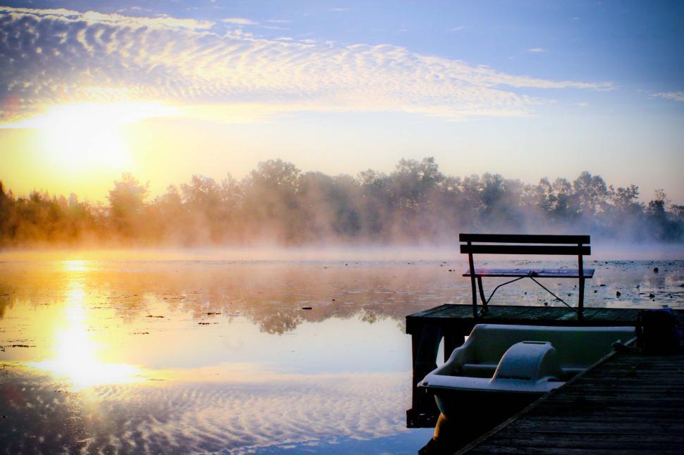 Free Image of Empty bench by the serene lake at sunrise, mist rising. 