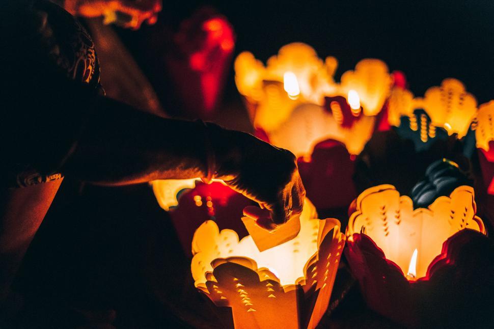 Free Image of Person lighting candles shaped in ornate floral designs 