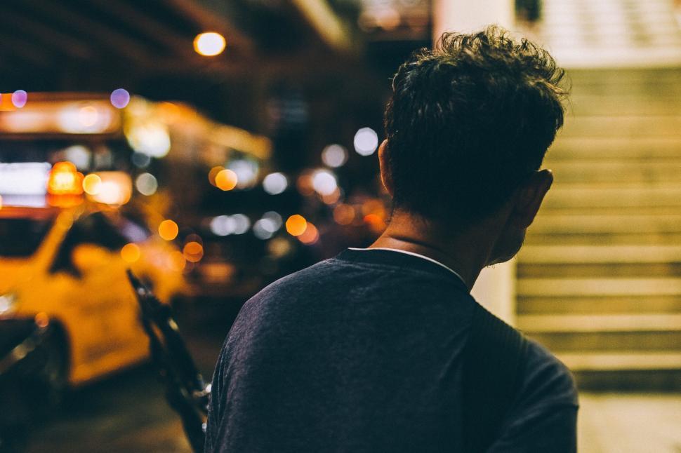Free Image of Person viewed from the back in an urban night setting 
