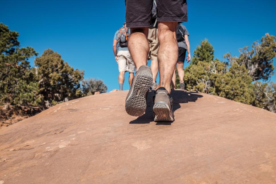 Free Image of Hikers climbing rocky path under the clear sky 