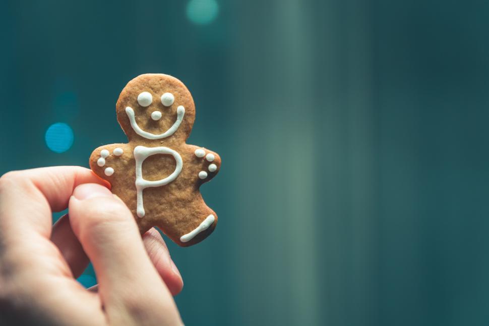 Free Image of Hand holding decorated gingerbread cookie character 