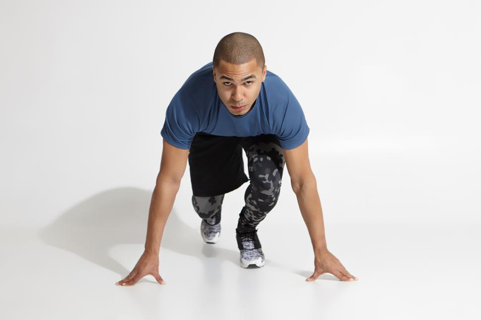 Free Stock Photo of Serious mixed race man standing in steady position preparing to run. Muscular dark skinned male runner ready for running exercise. Health and active lifestyle. Sport fitness energy...