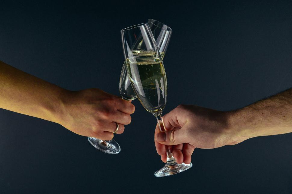 Free Image of Two people clinking champagne glasses in a celebration 