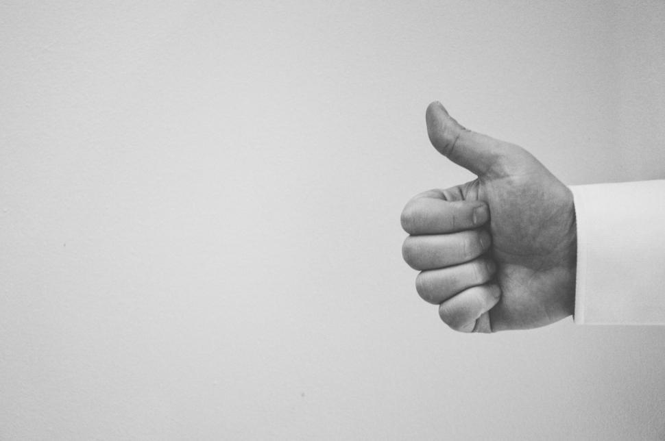 Free Image of Hand showing thumbs up gesture on light background 
