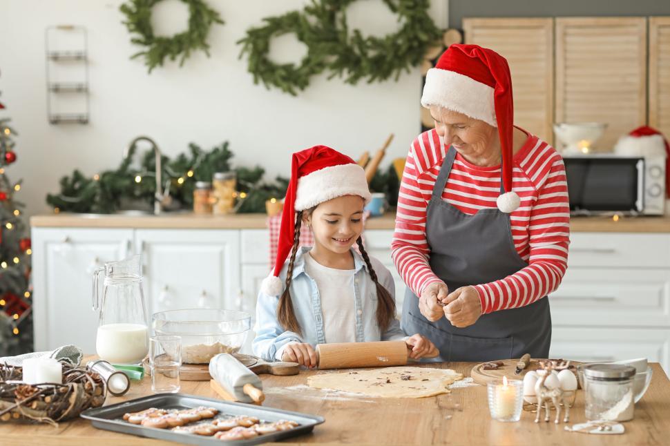 Free Image of Grandmother and girl bake cookies in festive kitchen 