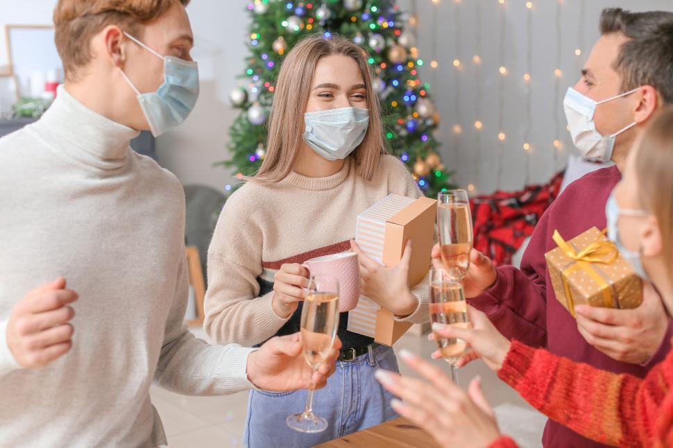 Free Image of Masked friends cheering with Christmas gifts 
