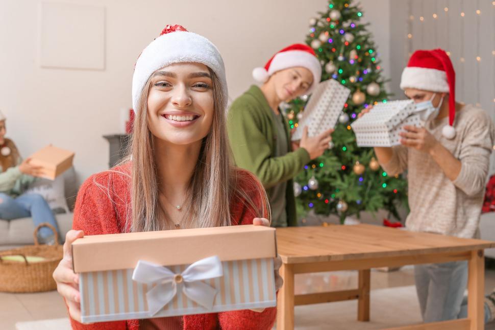 Free Image of Woman smiling with gift box at Christmas celebration 