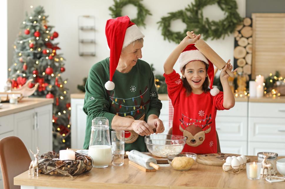 Free Image of Grandmother and granddaughter baking in festive setting 