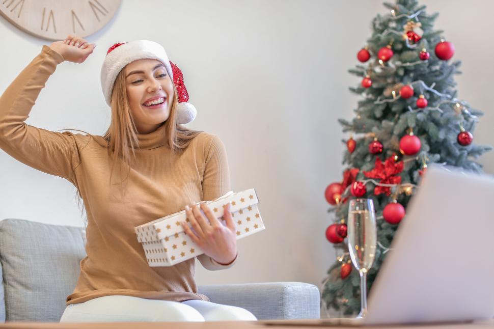 Free Image of Smiling woman with gift during Christmas video call 