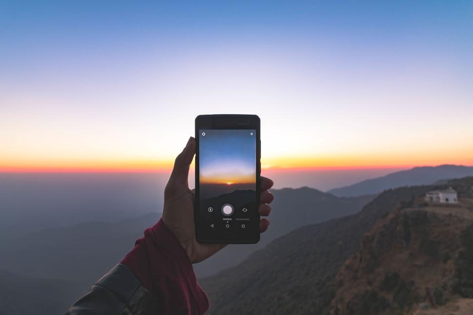 Free Image of Capturing a sunset over mountains using a smartphone 