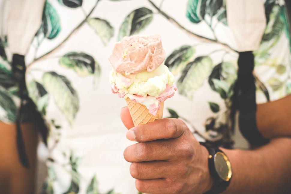 Free Image of Hand holding an ice cream cone with multiple scoops 