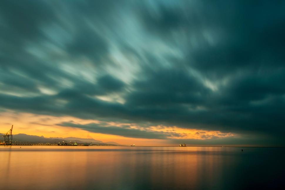 Free Image of Long exposure of sea with dramatic clouds at sunset. 