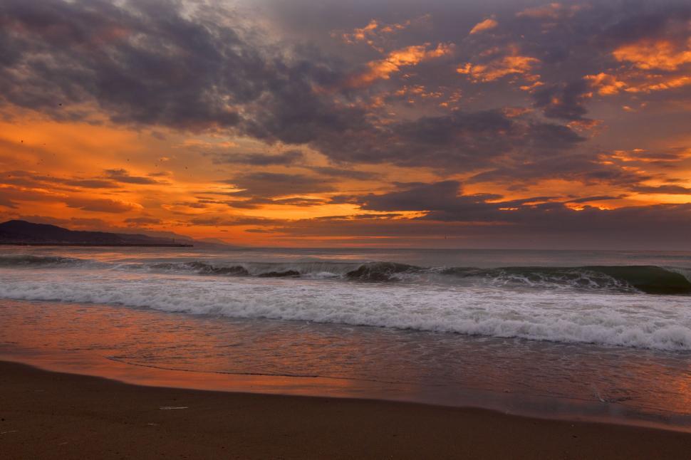Free Image of Sunset at beach with vibrant orange and pink sky. 