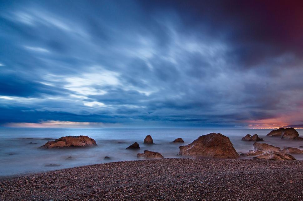Free Image of Rocky seashore under dramatic and moody evening sky. 