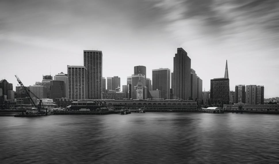 Free Image of Black and white cityscape with buildings and waterfront. 
