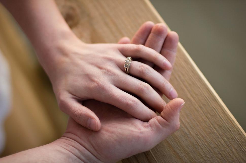 Free Image of Hands with wedding rings clasped together in affection. 