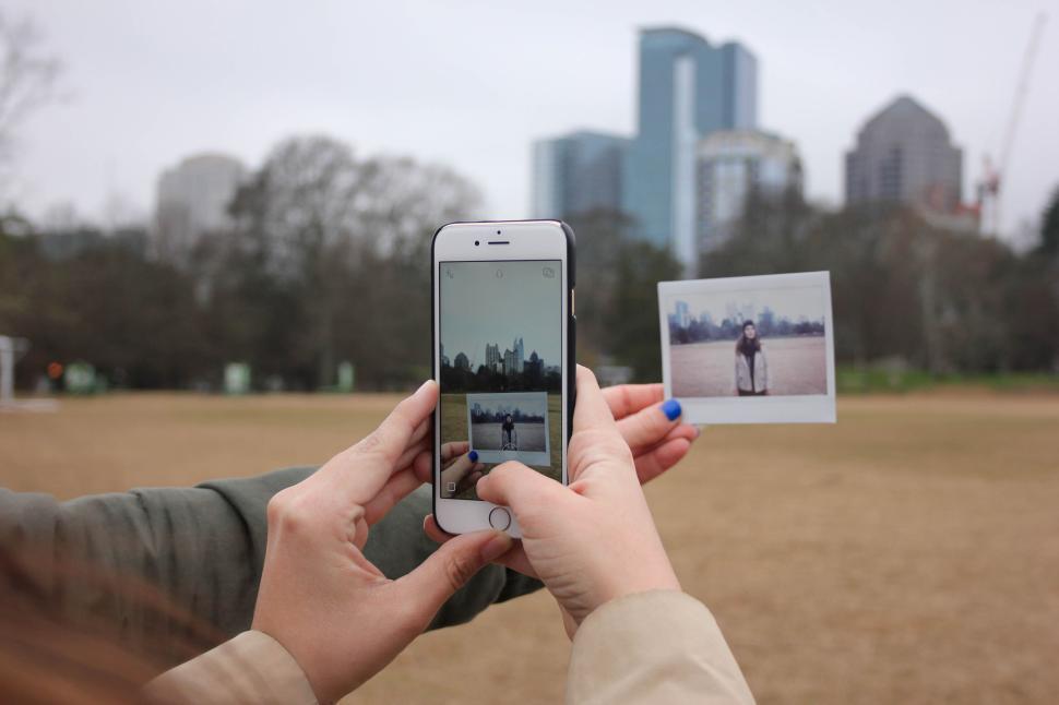 hands-holding-a-phone-taking-a-photo-of-a-polaroid-picture.jpg