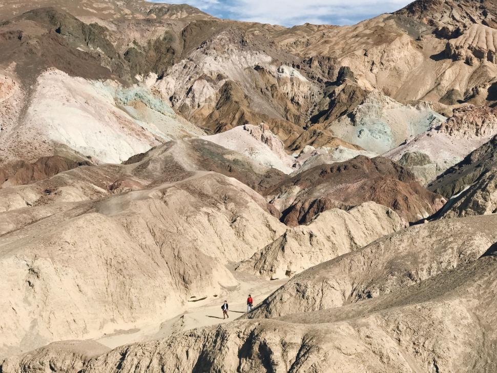 Free Image of Hikers walking through a rugged mountain terrain landscape. 