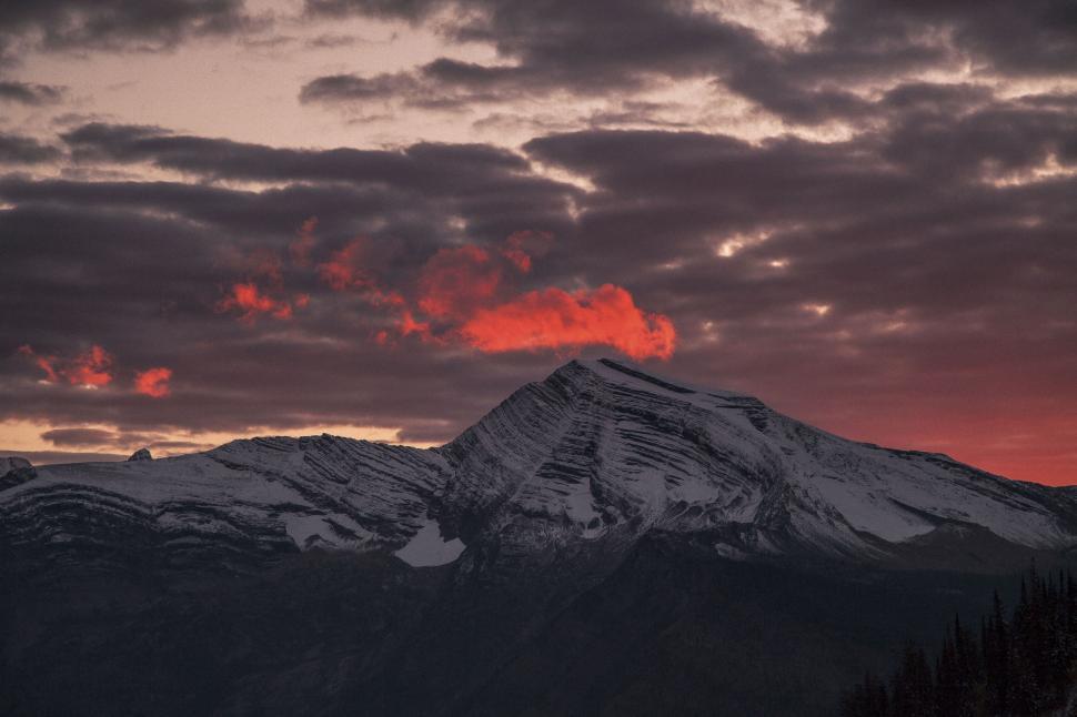 Free Image of Mountain peak with dramatic fiery clouds during sunset. 