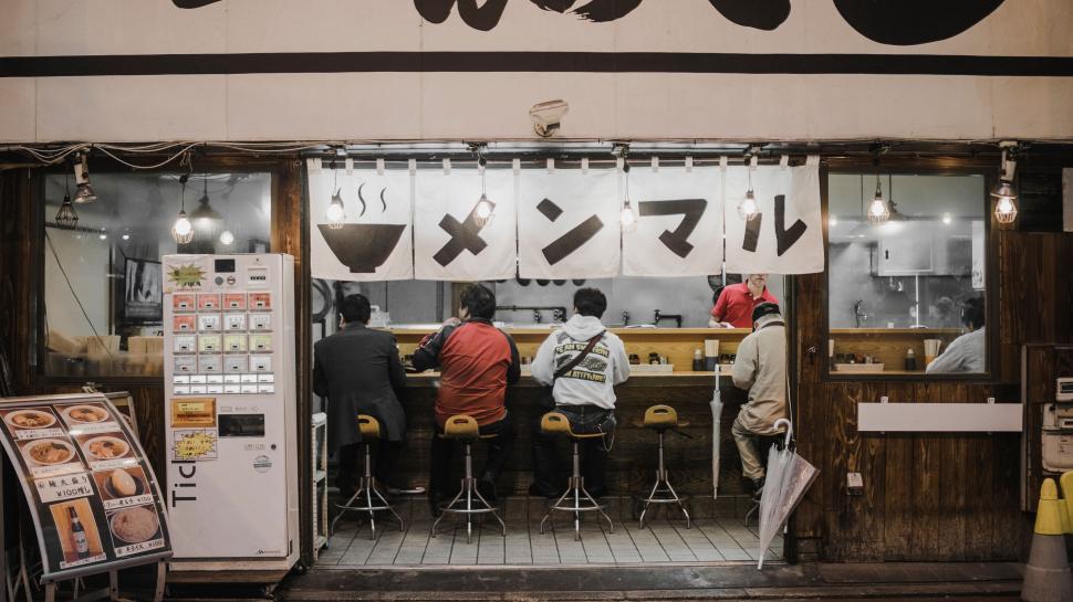 Free Image of Patrons seated at the counter of a ramen restaurant 