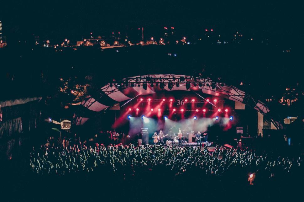 Free Image of Open-air concert with large audience and bright lighting. 