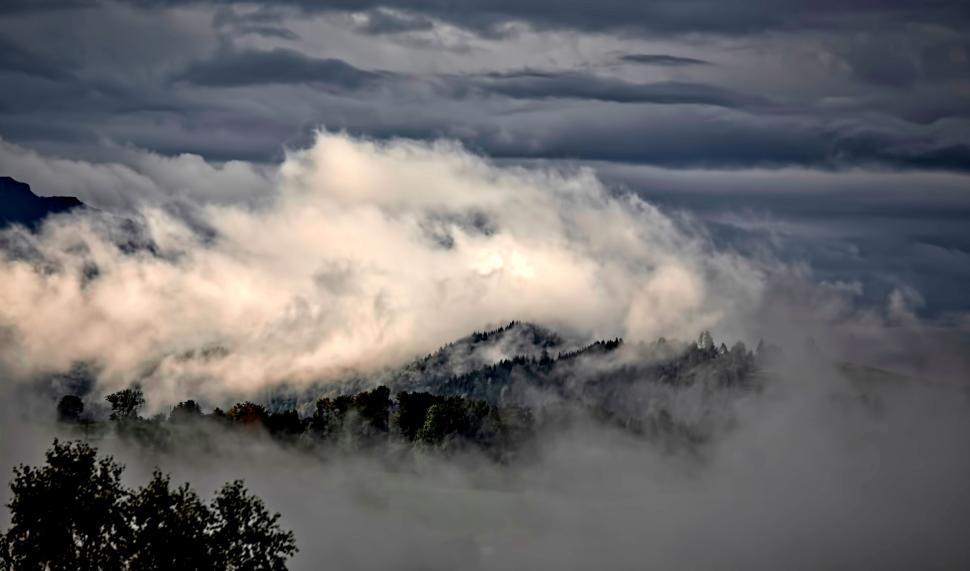 Free Image of Mountainous landscape covered in dense clouds and fog 