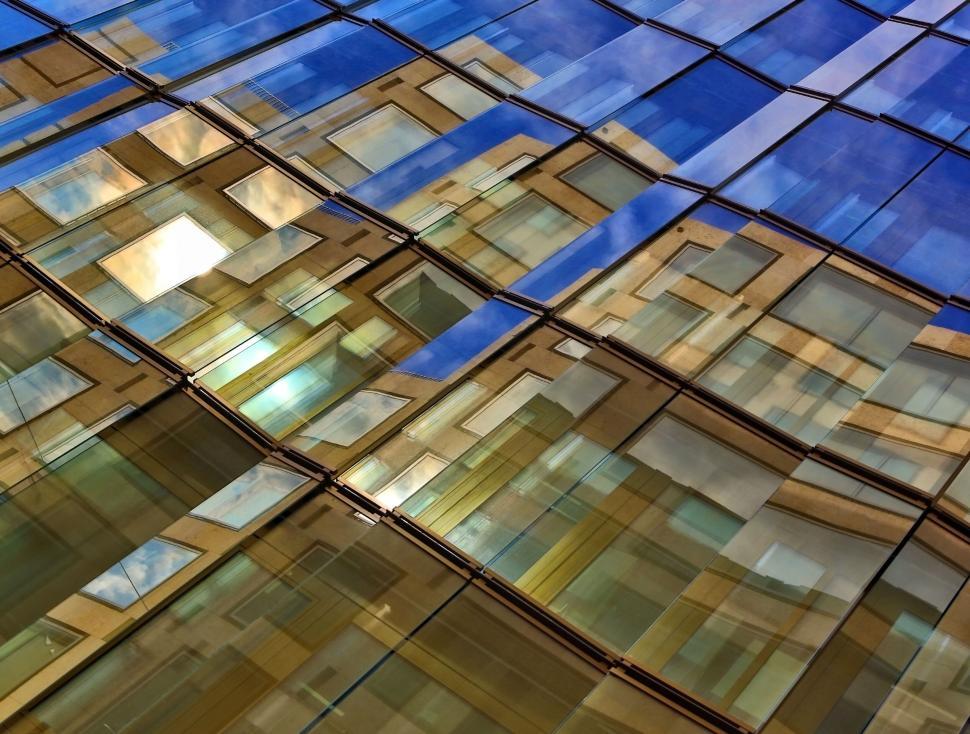 Free Image of Reflections of a modern glass building during sunset. 