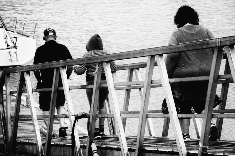 Free Image of Family walking down ramp towards a dock near water 