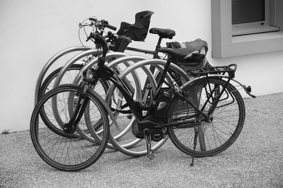 Free Image of Parked bicycles in a row against a building block 