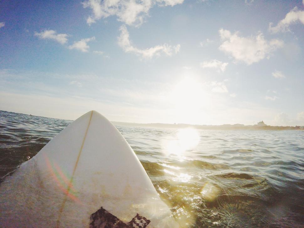 Free Image of Surfboard nose points at the horizon during sunset. 