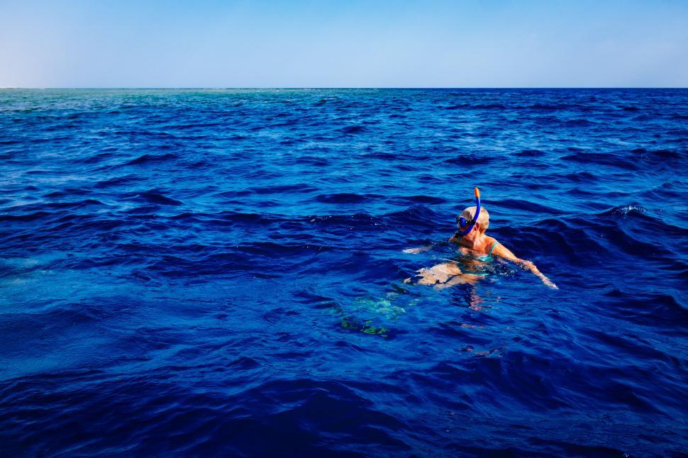 Free Image of Person snorkeling in deep blue water of the ocean 