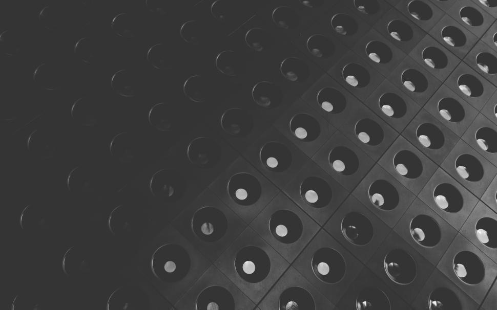 Free Image of Black surface with round holes creating an abstract pattern. 
