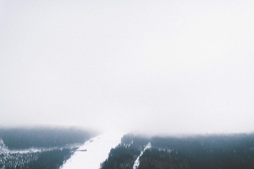 Free Image of Snow-covered mountain peaks with a cloudy sky background 