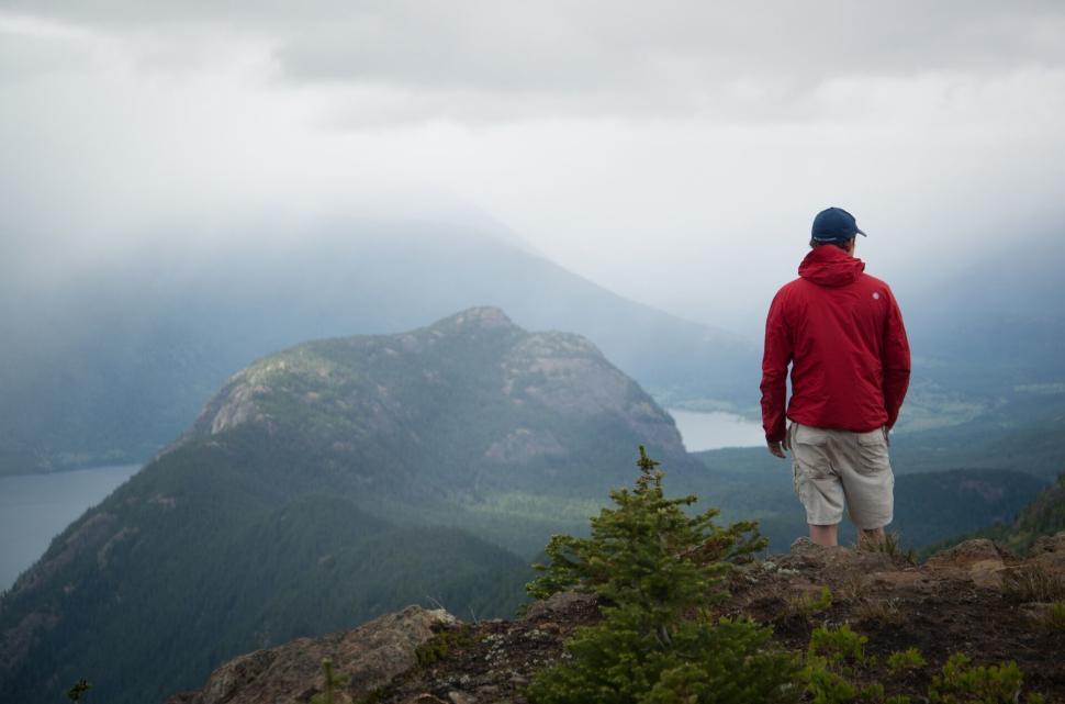 Free Image of Man in red jacket admiring mountains and landscape view 