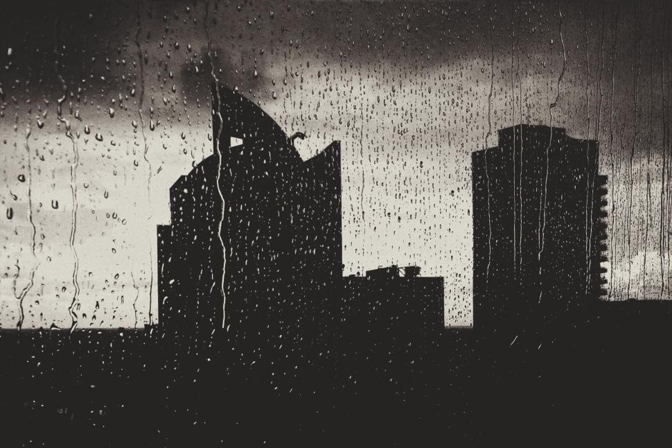 Free Image of Rainy cityscape with silhouetted buildings at dusk. 