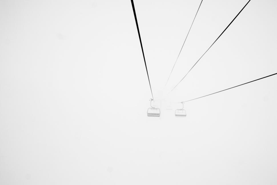Free Image of Cable cars moving in white mist on a thin wire 